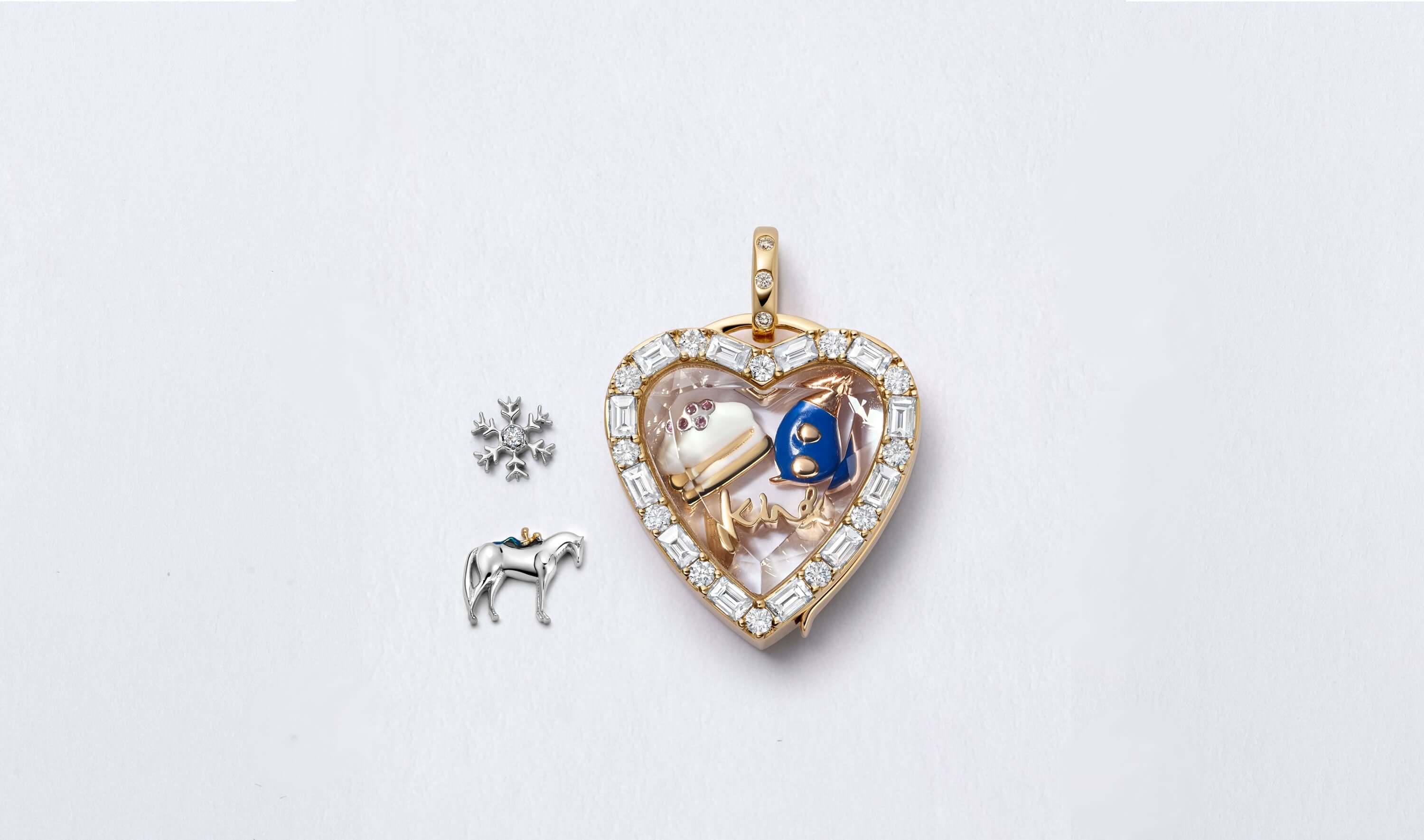 Heart baguette diamond locket pendant personalised with a mole, a piece of cake and the king word charms and a snowflake and horse charm next to the pendant